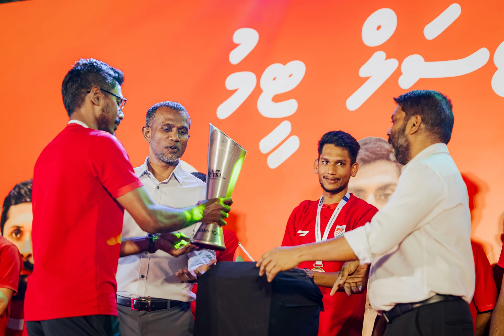 ރަން ތަށި ހޯދި ޓީމުގެ ކެޕްޓަން މުހައްމަދު އިމްރާން (އިންމި)، ފުޓްސަލް ޓީމުން ހޯދި ތަށި ކުޅިވަރު ވަޒީރު އަދި އެފްއޭއެމްގެ ރައީސްއާ ހަވާލުކުރަނީ. ފޮޓޯ: ފަހުމިނެޓް